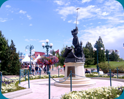 Standbeeld als eerbetoon aan diverse Disney imaginieers voor de ingang van de Disneyparken met Disney Village op de achtergrond
